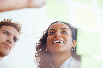 Buy stock photo Business man and woman posting message on adhesive notes stuck on glass
