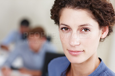 Buy stock photo Closeup portrait of a young businesswoman with her colleagues sitting in the background