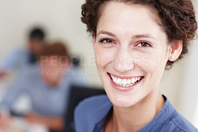 Buy stock photo Closeup portrait of a smiling young businesswoman with her colleagues sitting in the background