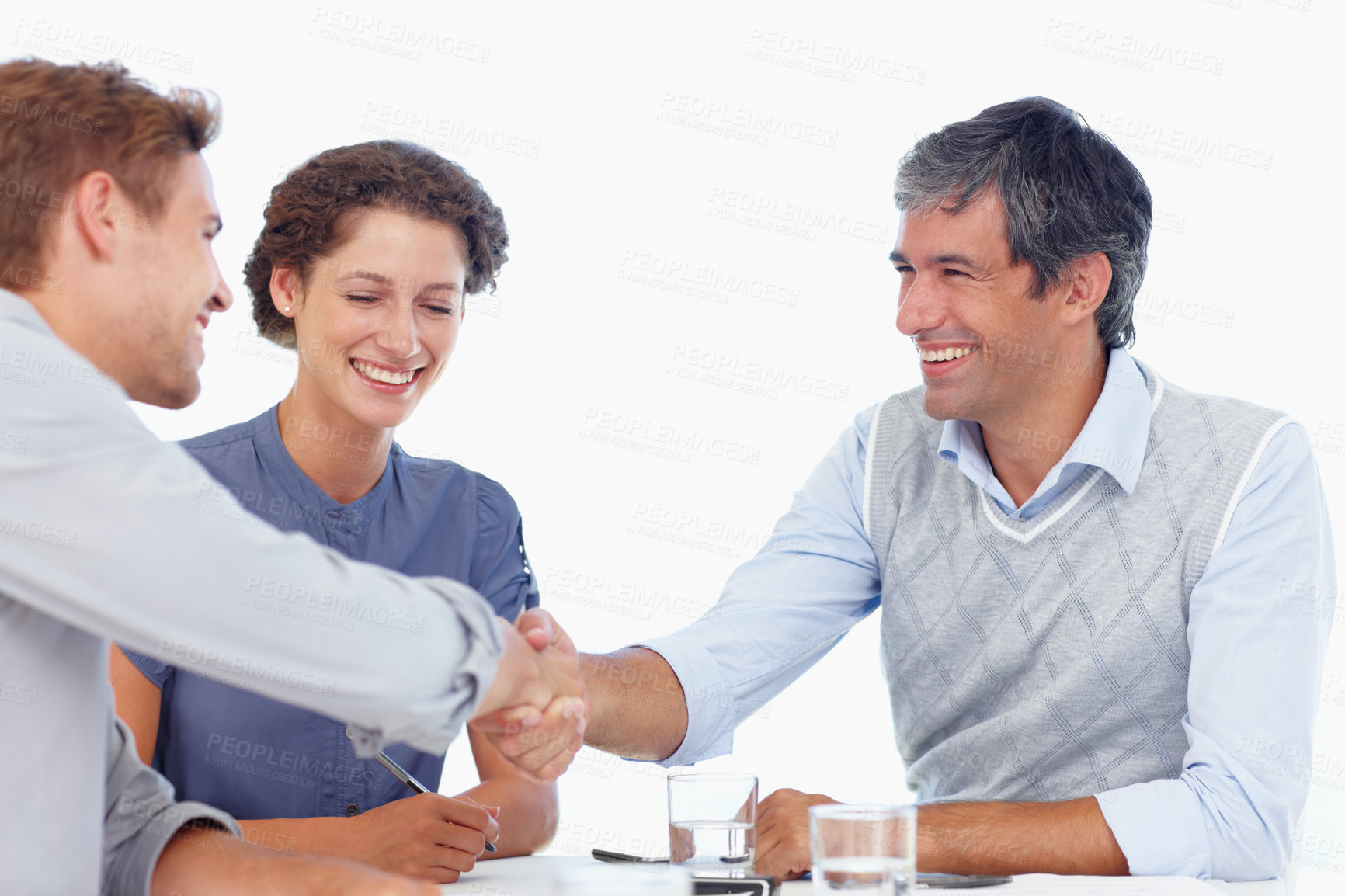 Buy stock photo Shot of two businessmen shaking hands while in a meeting with a female coworker