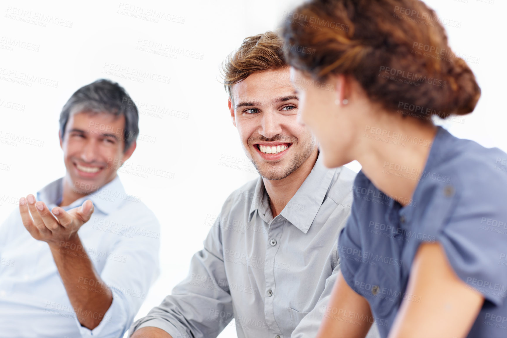 Buy stock photo Shot of three positive-looking businesspeople talking together in a meeting