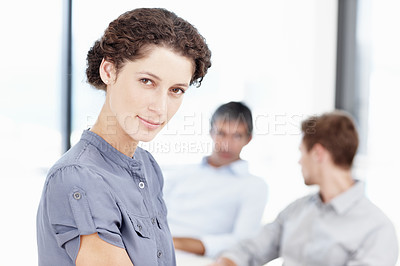 Buy stock photo Portrait of a confident female office worker with colleagues sitting behind her
