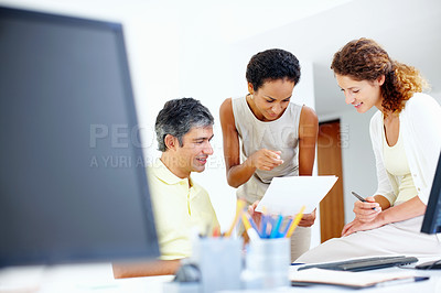 Buy stock photo Casually dressed executives taking a look at paperwork