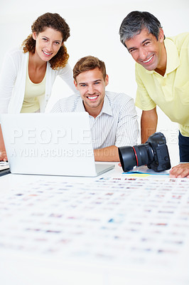 Buy stock photo Portrait of three photographers using laptop and giving you an attractive smile