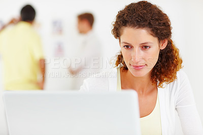 Buy stock photo Closeup of cute business woman using laptop with colleagues in background