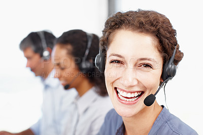 Buy stock photo Closeup portrait of a laughing call center professional with colleagues seated in the background