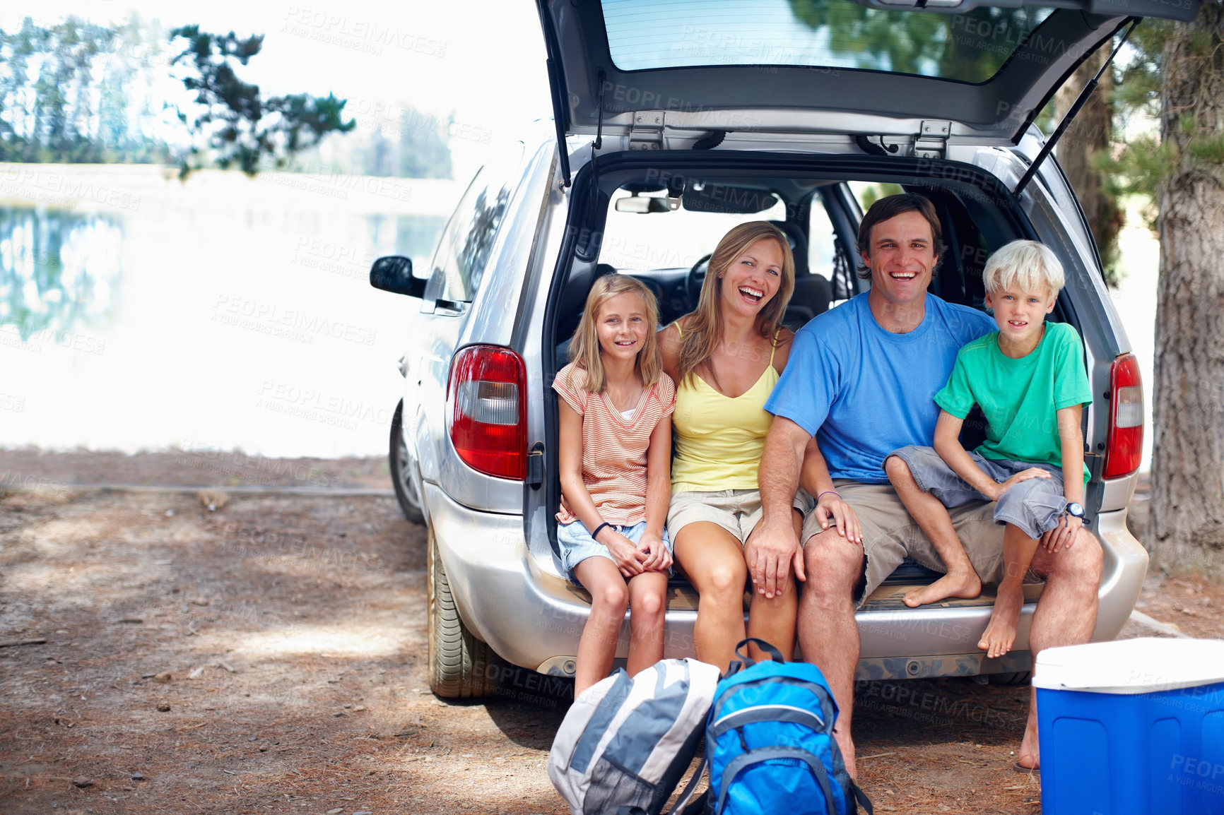 Buy stock photo Family, portrait and relax by car for camping in forest or outdoor, adventure and weekend trip for break. Happy, parents and children by lake in nature or wilderness for summer, holiday and bonding.