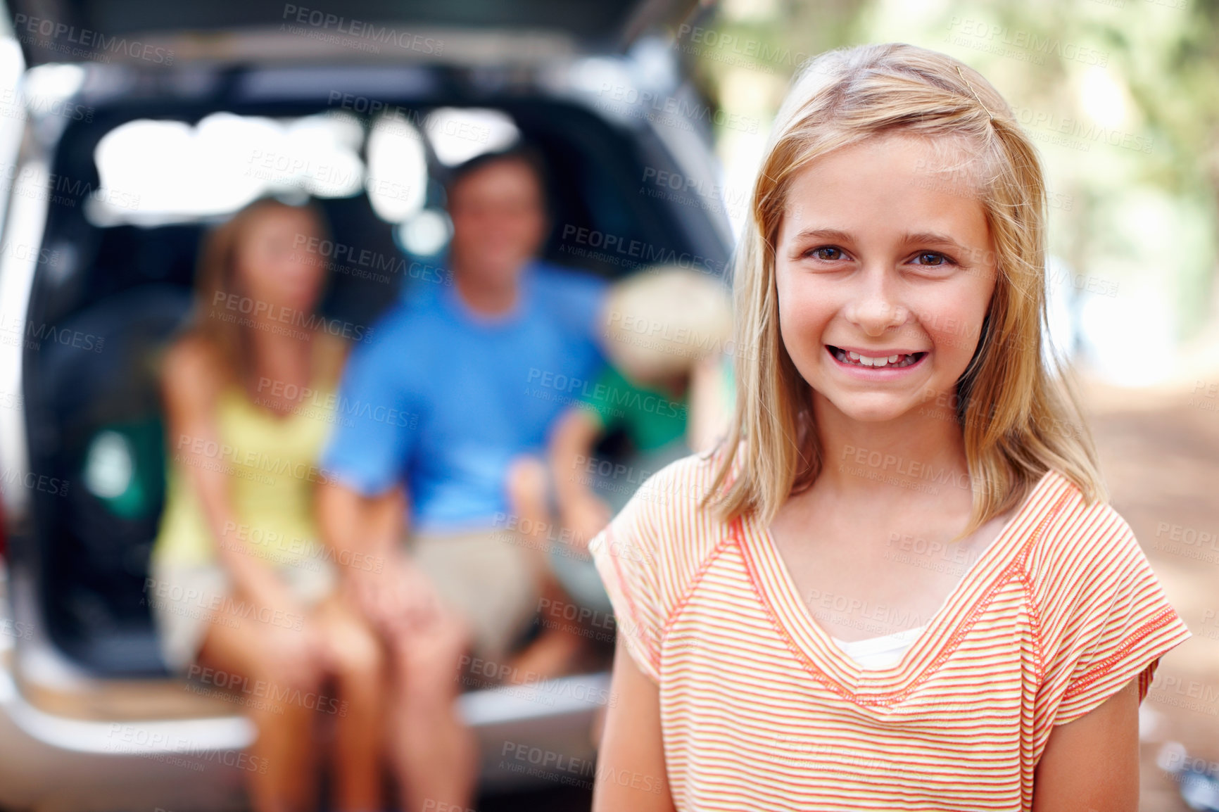 Buy stock photo Portrait, vacation and happy kid in nature for family trip with father, mother and sibling in suv car. Face, smile and girl child in forest for holiday, adventure and travel with parents in transport