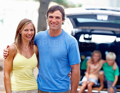 Buy stock photo Portrait of couple smiling with kids sitting in the back of a car