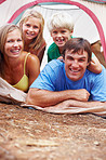 Family relaxing in tent and smiling