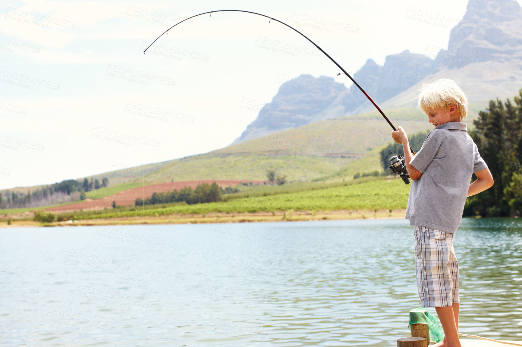 Buy stock photo Relax, boy and fishing by lake for vacation, learning and travel in summer with gear on dock by water. Kid, fun and catch fish in nature for adventure, holiday and development while camping with line