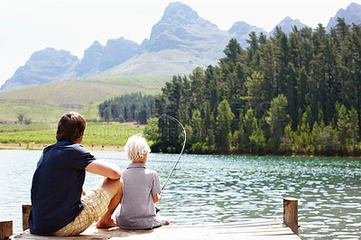 Buy stock photo Dad, boy and fishing by lake for teaching, vacation and travel together in summer with gear on dock. Father, son and catch fish in nature for learning, holiday and development while bonding with line