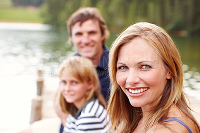 Buy stock photo Portrait, woman and holiday in nature, lake and vacation for parents and child, outdoor and fun. Water, mom and dad with kid, bonding and travel to river for peace, relax and man with family in Texas