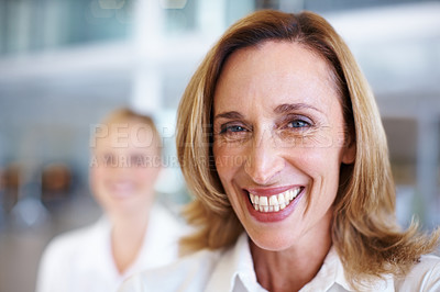 Buy stock photo Closeup of elegant mature female executive smiling with business woman in background
