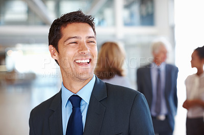 Buy stock photo Portrait of smiling young business man with executives discussing in background