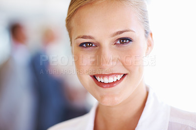 Buy stock photo Closeup of pretty female executive smiling with associates in background