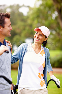 Buy stock photo Smiling couple standing on golf course and looking at each other