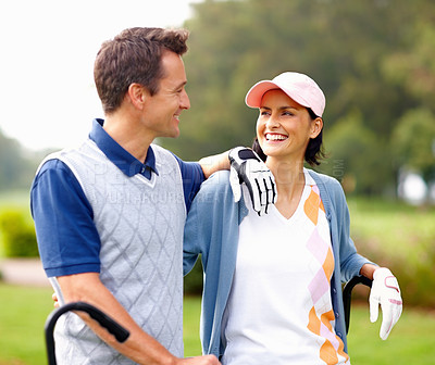 Buy stock photo Happy couple standing on golf course and looking at each other
