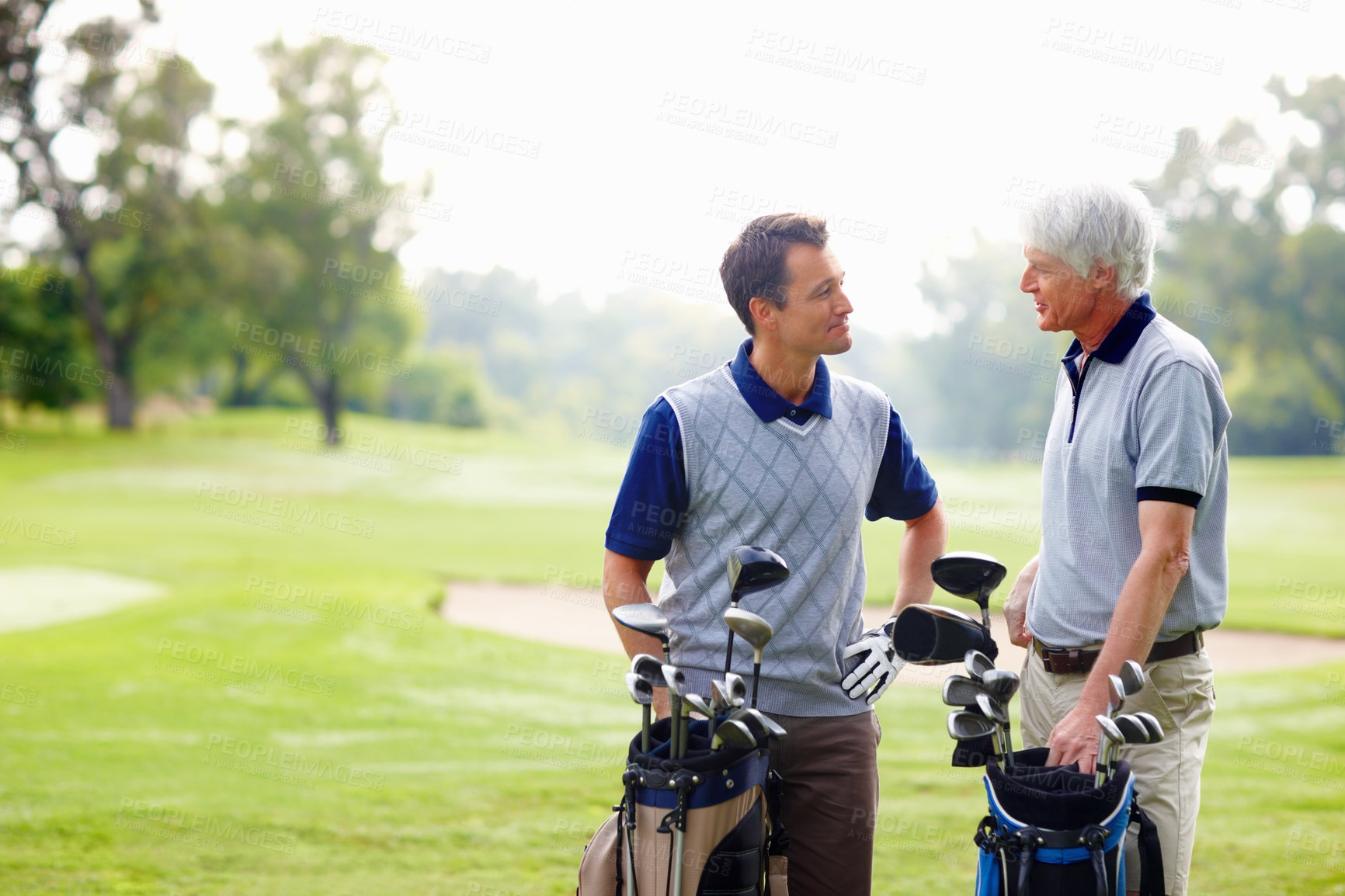 Buy stock photo Father, son and happy on course for golf, talking and bonding outdoor with equipment bag or conversation. Elderly person, man and smile on grass for hobby, sports and playing game at country club