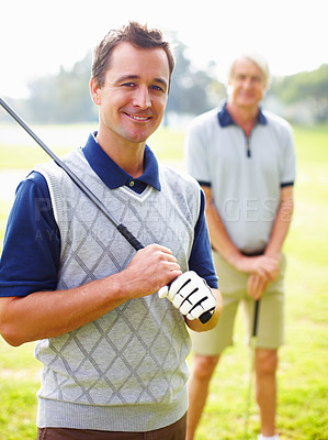 Buy stock photo Portrait of handsome man holding a golf club with father standing in foreground