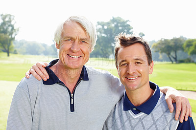 Buy stock photo Closeup of father and son standing on golf course with arms around and smiling