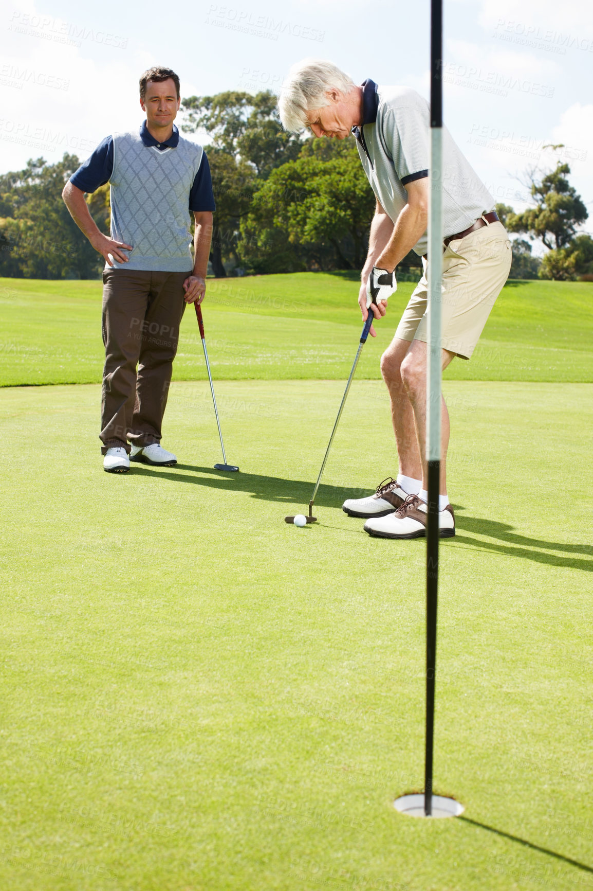 Buy stock photo Game, hole and men on golf course together for teamwork, outdoor fun and fitness competition at club. Sports, senior father and son on green for partnership, bonding and support in healthy hobby.