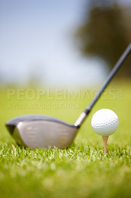 Buy stock photo Golf ball carefully balanced on a golf tee with a club in the background