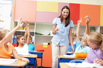 Buy stock photo Learning, children and answer teacher in classroom for question, assessment and education support. Smart students, lesson and hands raised with knowledge, exam quiz and feedback at elementary school