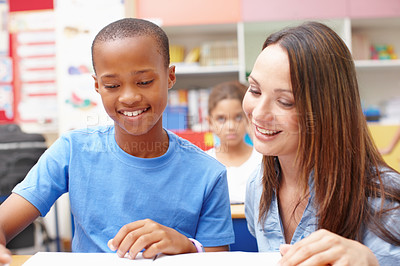 Buy stock photo An attractive young teacher helping a student with his schoolwork