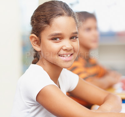 Buy stock photo Smile, portrait and girl in classroom for writing test, growth and child development at elementary school. Happy, face and student at desk for kids education, study and assessment for scholarship.