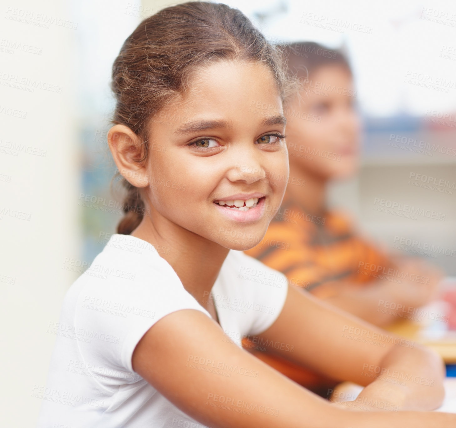 Buy stock photo Smile, portrait and girl in classroom for writing test, growth and child development at elementary school. Happy, face and student at desk for kids education, study and assessment for scholarship.