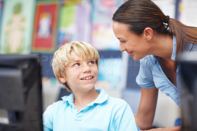 Buy stock photo An attractive young teacher assisting a schoolboy during computer class