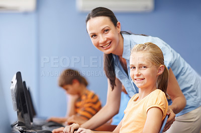 Buy stock photo Portrait of an attractive young teacher assisting students in their computer class