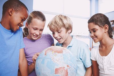 Buy stock photo A group of schoolkids learning about the world using a globe of earth