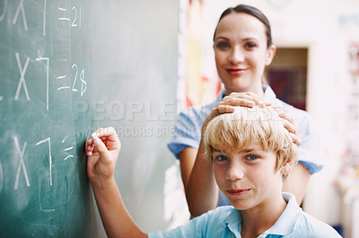 Buy stock photo A young student with a friendly and fun relationship with his teacher doing maths on the blackboard
