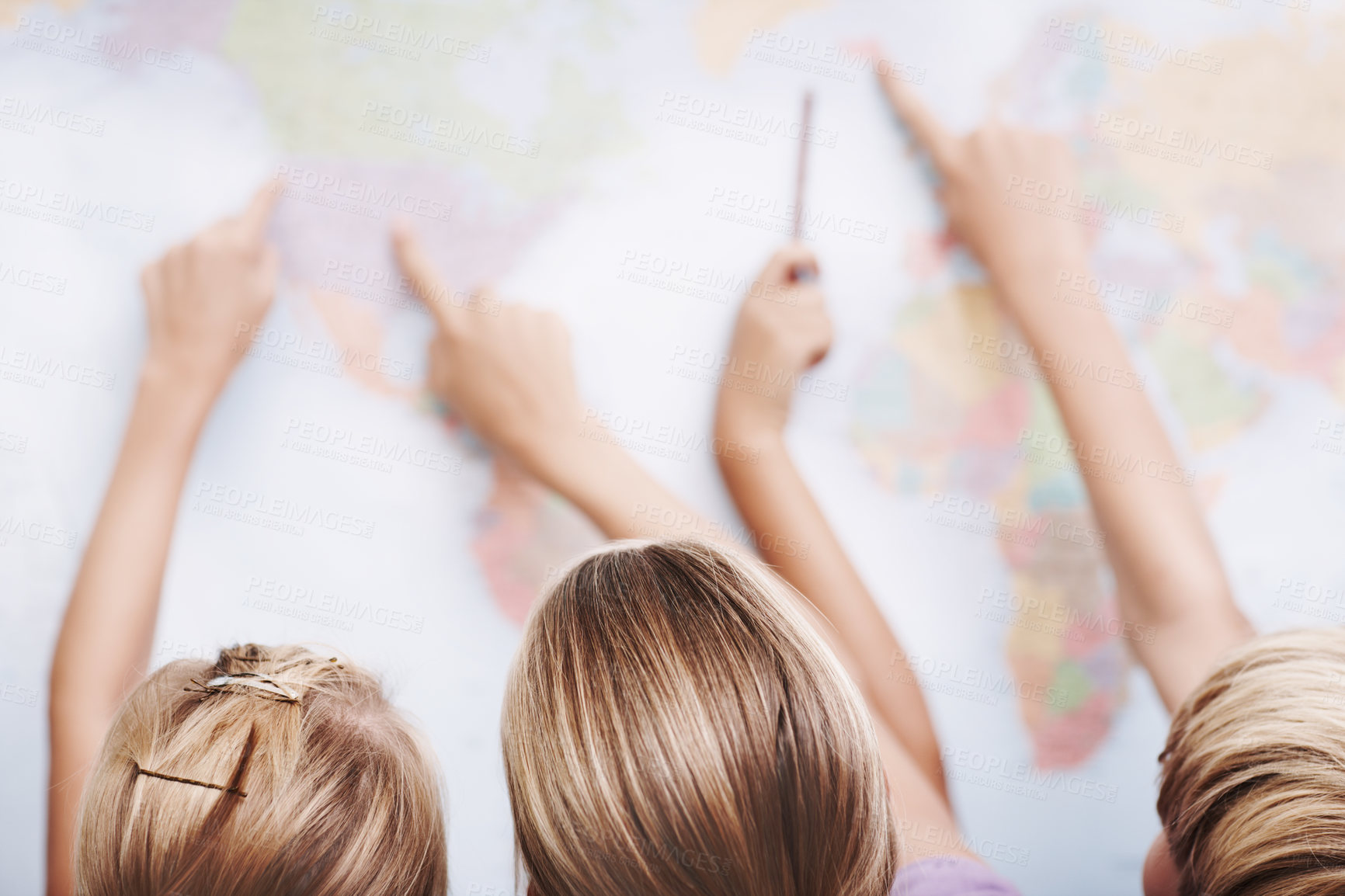 Buy stock photo Rear view of a group of schoolchildren pointing at a world map