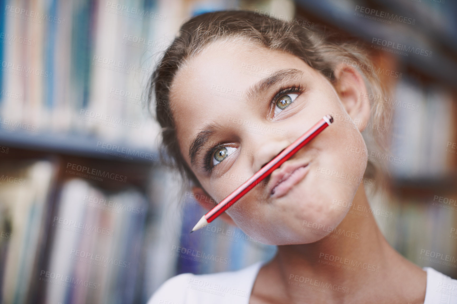 Buy stock photo A cute young girl balancing her pencil on her lips and pulling a face