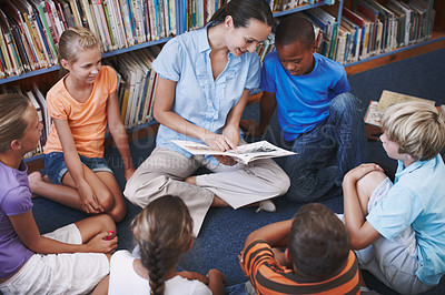 Buy stock photo Teacher, group and children for education in library with book discussion, creative reading and learning. Circle, woman and students support for storytelling, teaching advice and language development