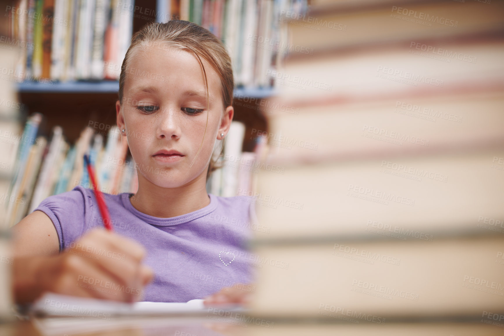 Buy stock photo Girl, writing and thinking in library for education, knowledge and study for development at elementary school. Young student, learning and books on table for lesson, growth and progress in assessment