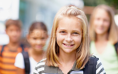 Buy stock photo Cute schoolgirl smiling with school friends behind her in the background - copyspace