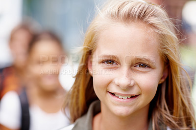 Buy stock photo Closeup of a cute primary school girl smiling at you with friends in the background