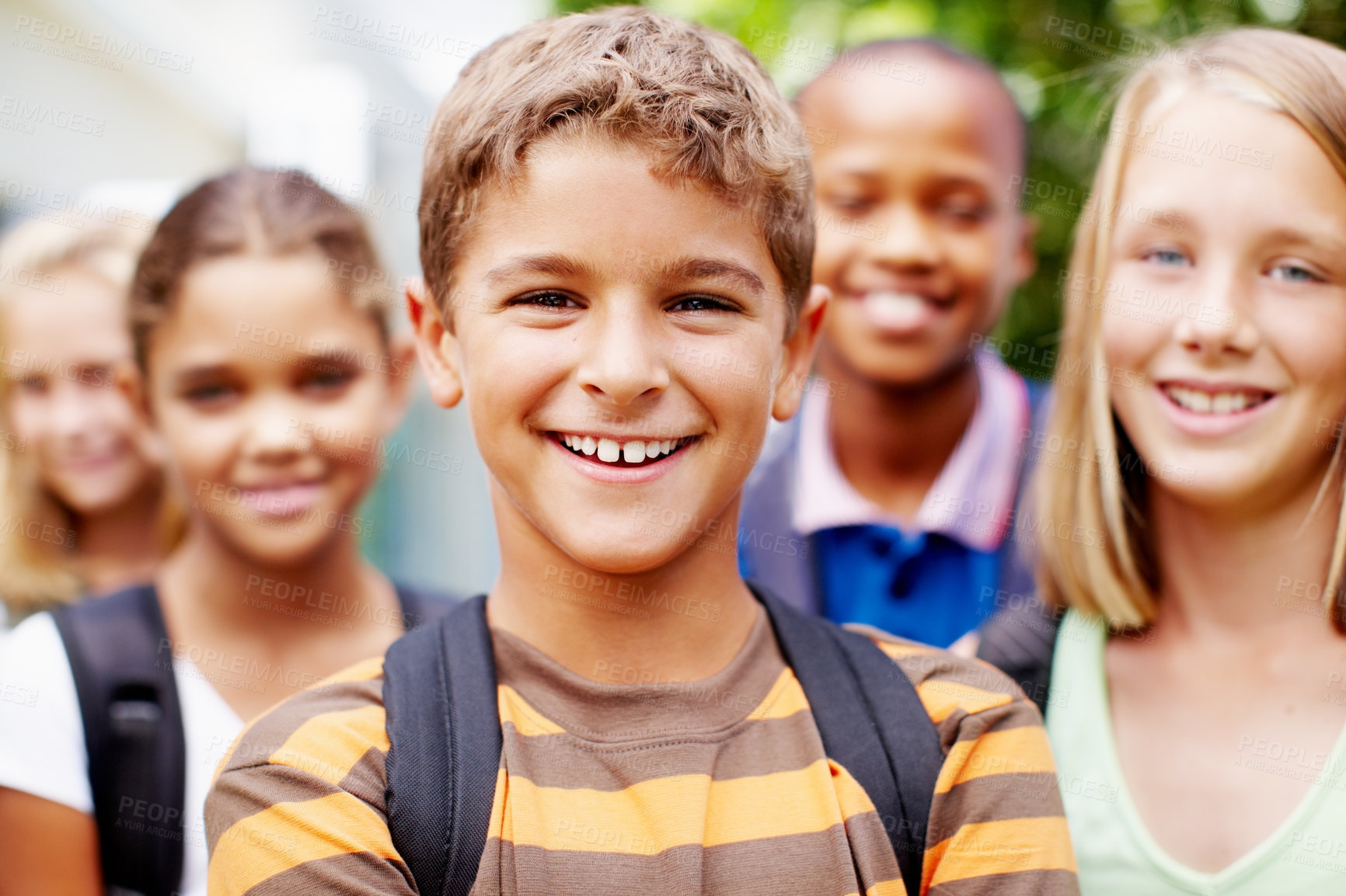 Buy stock photo Confident young schoolboy posing for the camera with his school friends