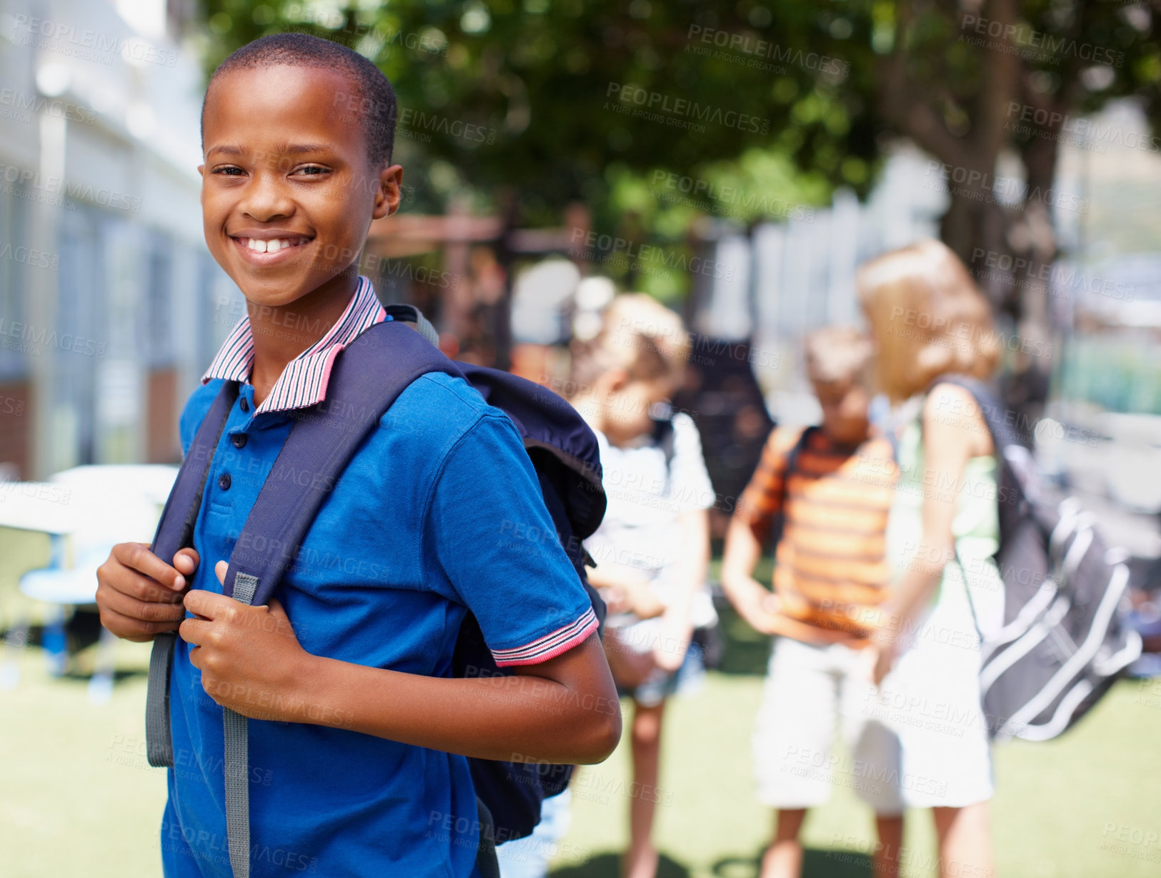 Buy stock photo Smiling african american boy posing outside with school friends in the background - copyspace