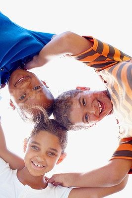 Buy stock photo Three sweet kids with their heads together smiling down at the camera