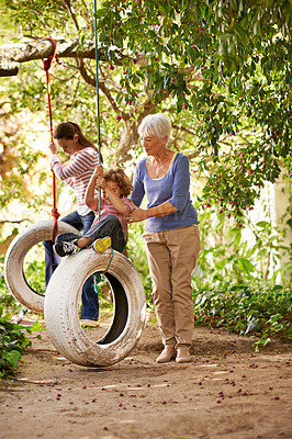 Buy stock photo Senior woman, garden and grandma pushing her grandchildren on a tyre swing or holidays and having fun in summer. Excited, grandkids and elderly woman outdoors on jungle gym or on sunny day at a park