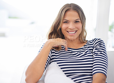 Buy stock photo Portrait of an attractive young woman sitting on the sofa at home