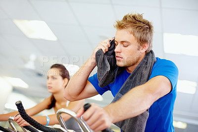 Buy stock photo Young man tired while cycling at the gym