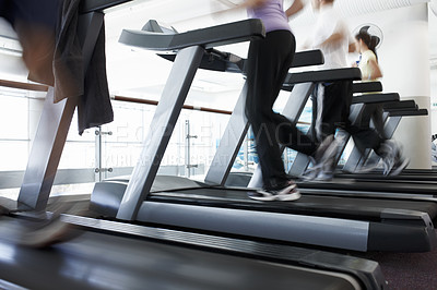 Buy stock photo Cropped shot of a people running on the treadmills at the gym