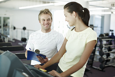 Buy stock photo Cropped shot of an attractive young woman working out with her personal trainer