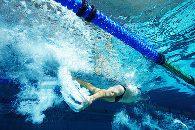 Buy stock photo Rearview of a  young male competitor swimming freestyle in a pool